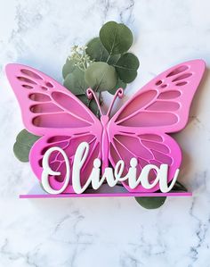 a pink butterfly with the word elevo on it and some flowers in front of it