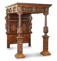 an elaborately carved wooden bed frame with pillars and carvings on the sides, along with two candlesticks