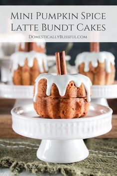 cinnamon bundt cakes with white icing and cinnamon sticks on top, sitting on a cake plate