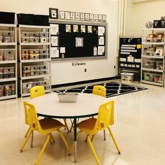 there is a table and chairs in the middle of this room with shelves on both sides