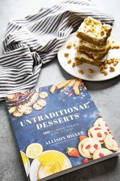 a stack of desserts sitting on top of a table next to a plate of cookies