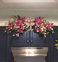 a kitchen with blue cabinets and pink flowers on the oven door, above it is a silver dishwasher