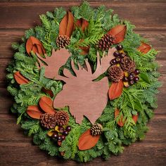 a christmas wreath with pine cones, evergreen leaves and deer's head cut out