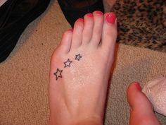 a woman's foot with three stars tattooed on her left toe and right foot