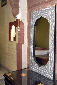 a mirror sitting on top of a table next to a wall