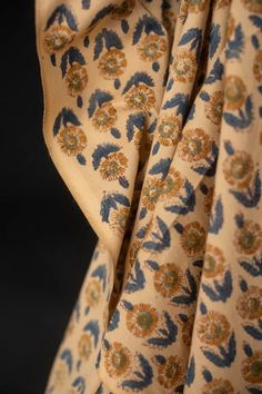 the fabric has blue and yellow flowers on it, as well as an orange flower