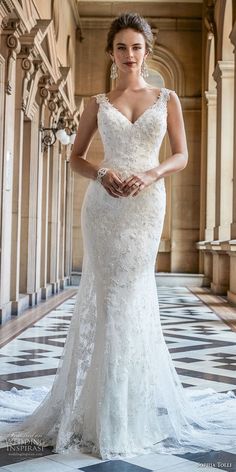 a woman in a white wedding dress standing on a tiled floor with an ornate archway behind her