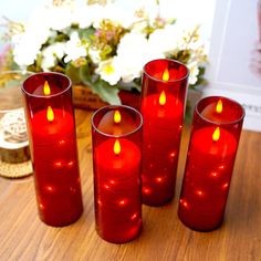 five red candles sitting on top of a wooden table