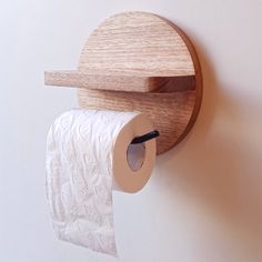 a roll of toilet paper hanging from a wooden holder