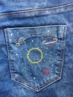 the back pocket of a pair of jeans with embroidered patches on it, showing different planets and stars