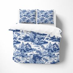 a blue and white bed with two pillows next to each other on top of a wall