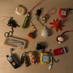 many different key chains and cell phones on a table