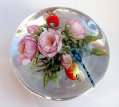 a glass bowl with flowers and a fish in it