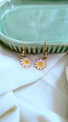 Add a touch of whimsy to your outfit with our Daisy Earrings. These adorable daisies will bring a smile to your face and brighten up any look. Perfect for adding a playful touch to your style. 🌼 Earring Details: White daisies Gold furnishings Trendy Daisy-shaped Spring Jewelry, Whimsical Spring Earrings For Pierced Ears, Trendy Nickel Free Flower Shaped Earrings, Trendy Nickel-free Flower-shaped Earrings, Cute Spring Drop Earrings, Whimsical White Earrings For Spring, Whimsical Spring Earrings With Flower Charm, Whimsical Spring Flower Earrings With Ear Wire, Trendy Spring Flower Earrings For Gift