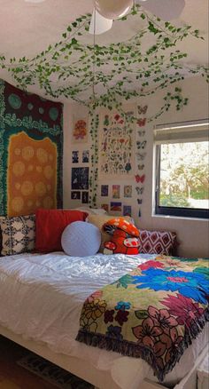 a bed with colorful pillows and blankets on top of it in front of a window