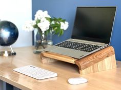 a laptop computer sitting on top of a wooden desk next to a mouse and keyboard