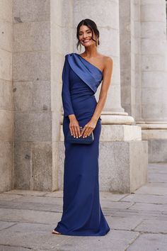 a woman in a blue dress posing for the camera with her hand on her hip