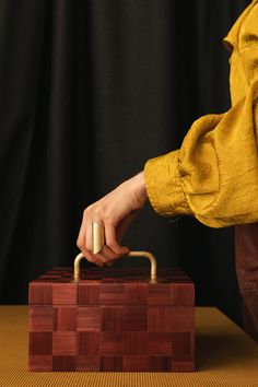 a person is holding the handle on a wooden box