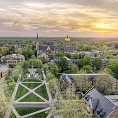 an aerial view of the campus and surrounding buildings at sunset, with trees in the foreground