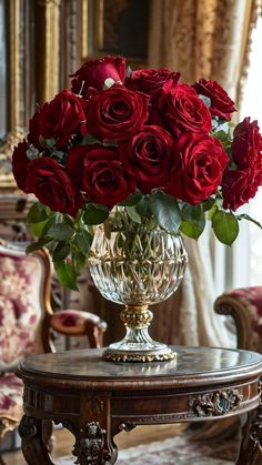 a vase filled with red roses sitting on top of a table next to a chair