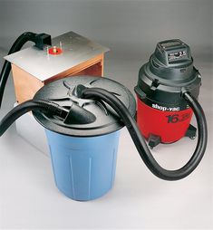 a red and black vacuum is next to a blue bucket with a hose on it