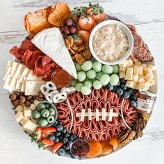 a football themed platter with cheeses, meats and vegetables