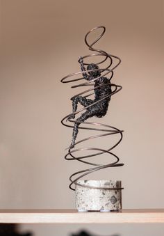 a metal sculpture sitting on top of a wooden table