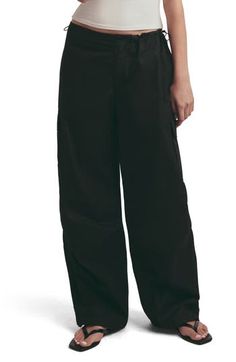 Draw inspiration from the baggy, low-slung fits of Y2K in these cotton cargo pants that cinch with drawcord toggles along the waistband. 31" inseam; 22" leg opening; 10 3/4" front rise; 12" back rise Zip fly with button closure; drawcord-toggle waist Front slant pockets; back patch pockets; cargo flap-patch pockets 100% cotton Machine wash, line dry Imported Black Cotton Parachute Pants With Drawstring, Sporty Cotton Parachute Pants For Work, Sporty Cotton Cargo Pants For Work, Sporty Cotton Wide-leg Cargo Pants, Sporty Wide-leg Cotton Cargo Pants, Cotton Cargo Pants, Favorite Daughter, Beauty Services, The Low