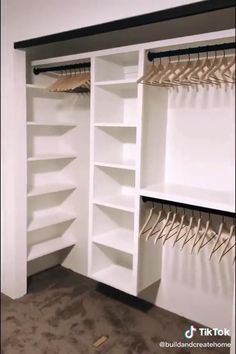 an empty closet with white shelves and lots of hangers