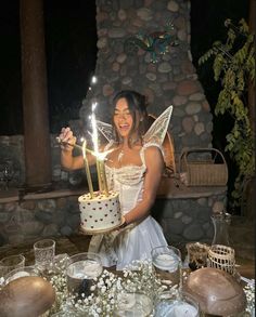 a woman holding a cake with candles in her hands