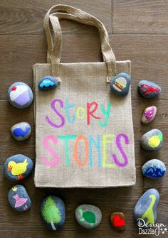 a tote bag with the words story stones painted on it surrounded by small rocks