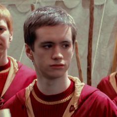 two young men in red sweaters standing next to each other