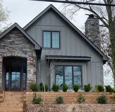 a house with stone walls and steps leading up to the front door is shown in this image