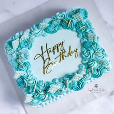 a happy birthday cake with blue icing and gold writing on it's side