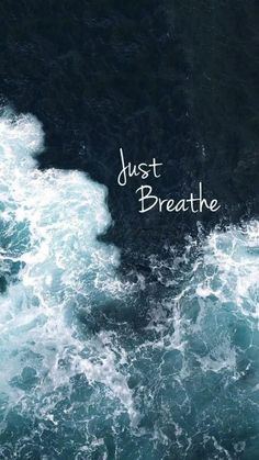 the words just breathe are written in white ink on top of dark blue ocean waves