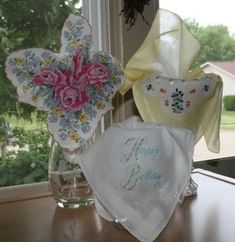 three handkerchiefs sitting on top of a table next to a window