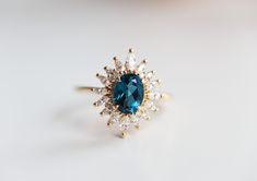 a blue and white diamond ring sitting on top of a table