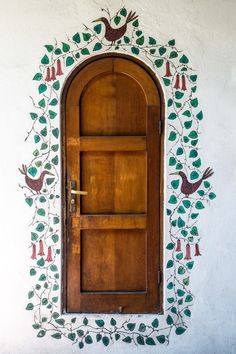 a wooden door with birds painted on it