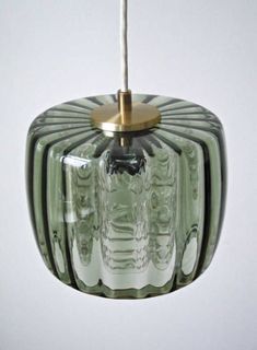 a green glass light hanging from a ceiling