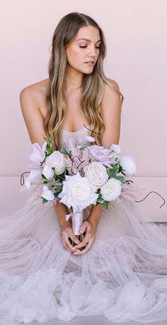 a woman sitting on the floor with flowers in her hands