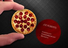 a hand holding a small pizza with pepperoni on it and an ad for joe robert's