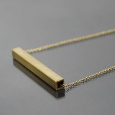 This simple brass necklace is made from brass colored chain and square brass tubing that I found at a salvage yard. The brass bar has been cut to 3" long, and a little over a 1/4" wide. I sanded the pendant to give it a brushed finish. You can select the length of the necklace from the drop box at the right side of the top of this page. The necklace has a gold plated hook and eye style clasp. This necklace is made to order, so it will vary slightly from the one pictured. The necklace is also ava Minimalist Brass Necklace With Rectangular Pendant, Minimalist Brass Necklace With Square Pendant, Found Object Jewelry, Brass Tube, Tube Necklace, Brass Bar, Music Jewelry, Drop Box, Jewelry Minimalist