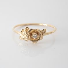 This mini rose flower ring is a beautiful little stacking ring that is like a little bouquet of gold roses and diamonds sitting on your finger. This ring is made in solid 14 karat gold with and set with a genuine VS-SI white diamond. Roses have long since represented love and romance, but are mainly known to represent God's love at work in the world. I made this ring as a reminder to us to always see the beauty and joy in the world. The simplicity of this ring stacks nicely with other rings and Delicate Rose Design Flower Ring For Wedding, Delicate Rose Design Rose Gold Ring, Delicate Rose Design Rose Colored Ring, Dainty Rose Design Flower Ring For Anniversary, Dainty Rose Design Flower Promise Ring, Delicate Rose Gold Diamond Flower Ring, Dainty Flower-shaped Stackable Promise Rings, Dainty Flower Shaped Stackable Promise Rings, Dainty Flower Stackable Promise Rings