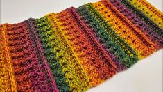 a multicolored crocheted dishcloth on a white surface