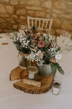 the table is set with flowers in vases and place settings for guests to sit at