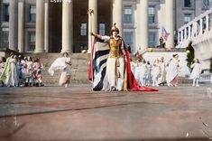 an old photo of a woman dressed in costume and holding a flag with other people behind her