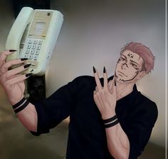 a man holding an old phone up to his face and making the peace sign with his hand