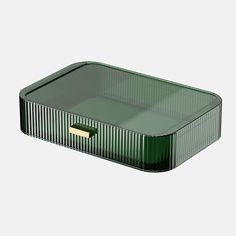 a green rectangular container with a gold lid