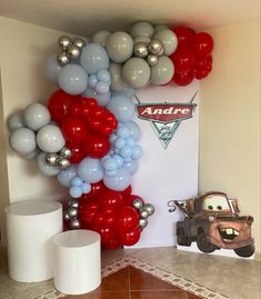 the balloon wall is decorated with cars and balloons