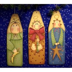 three wooden christmas ornaments hanging from a tree on a blue background with stars and snowflakes